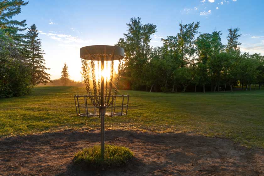 Disc Golf im Sonnenuntergang im bei Gegenlicht